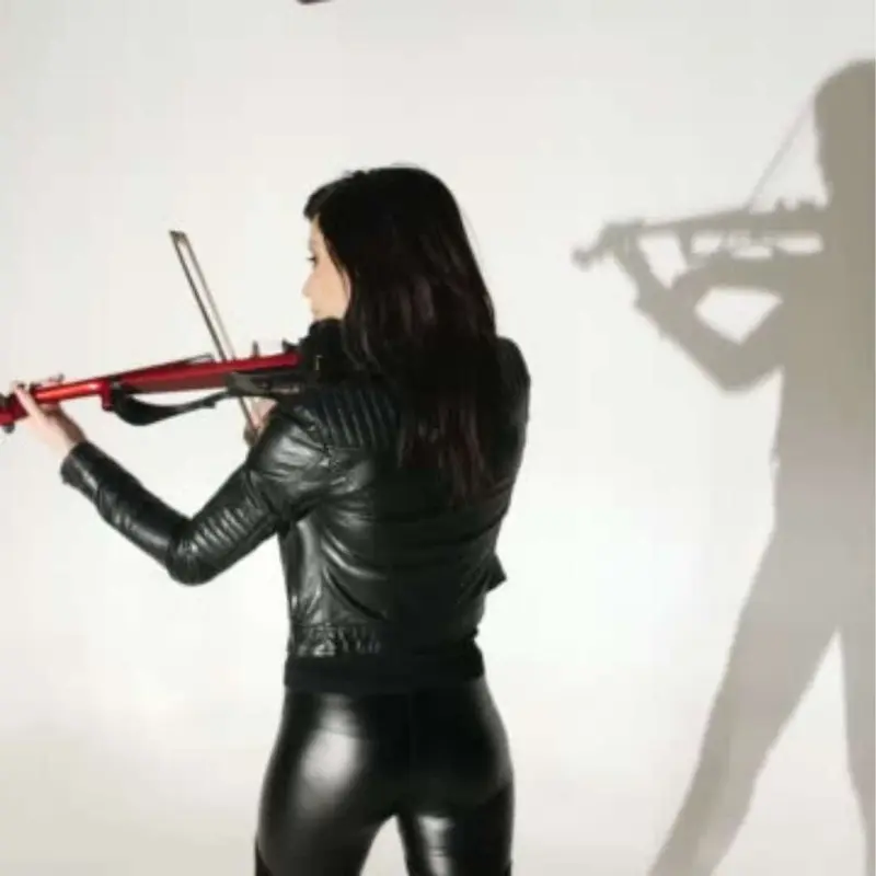 Violinist in a black leather jacket playing a red violin, seen from behind
